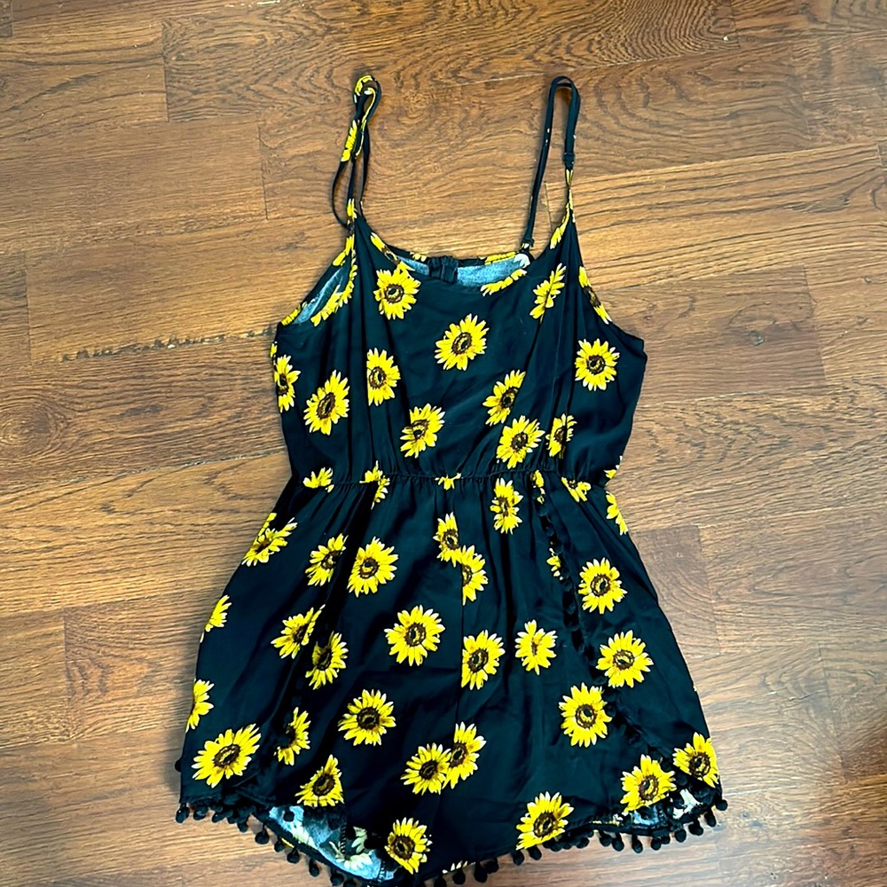 Sunflower romper with pom pom trim.